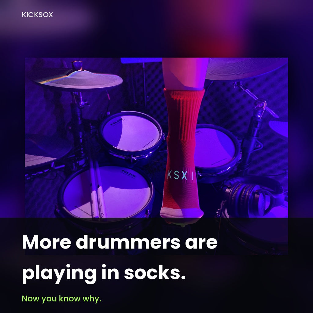 Drummer wearing a red KickSox sock at an electronic drum kit under stage lighting